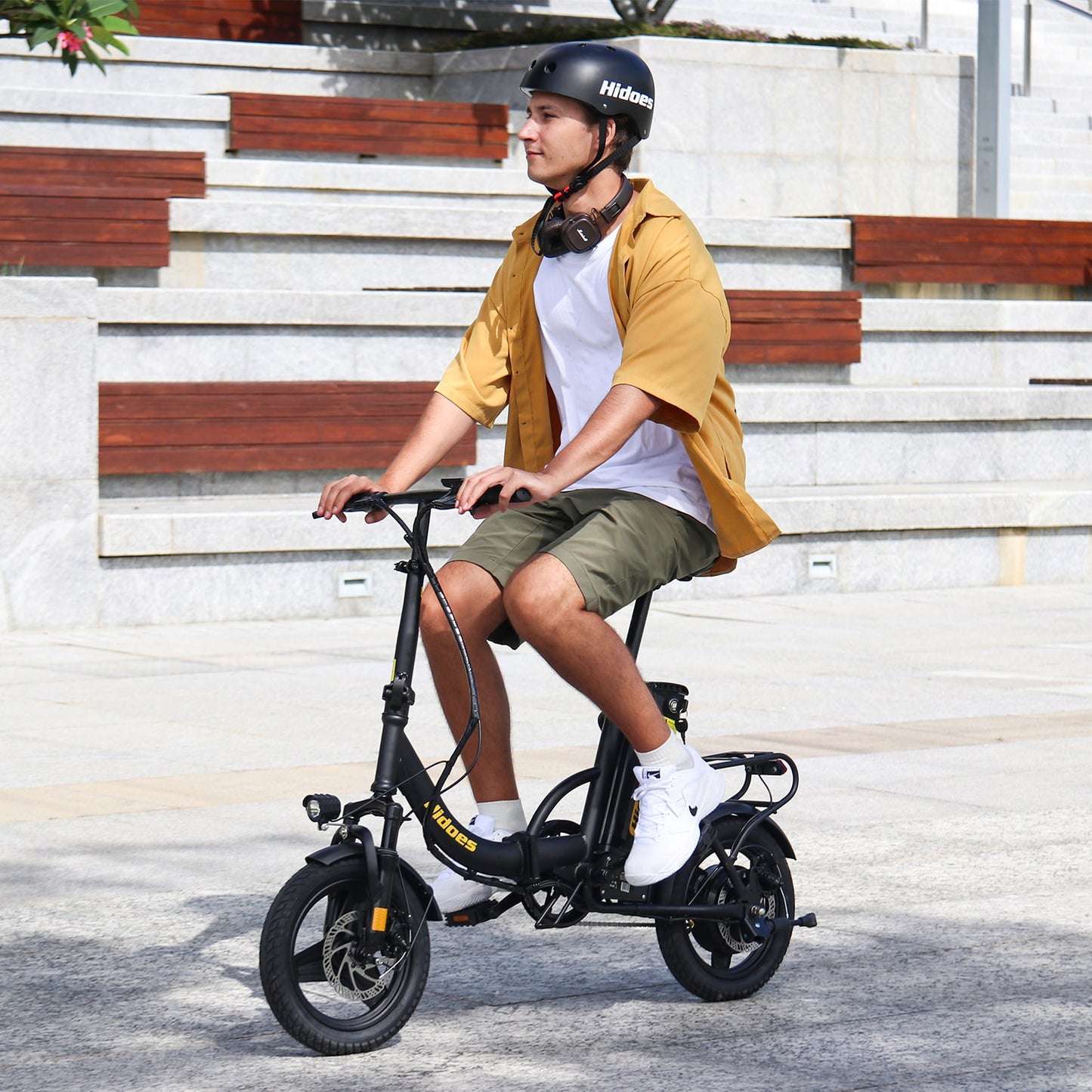 Person riding a black Hidoes C5 electric bike on a city street.