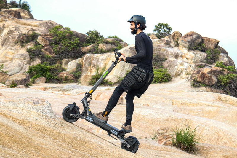 Person riding an electric scooter on a rocky trail